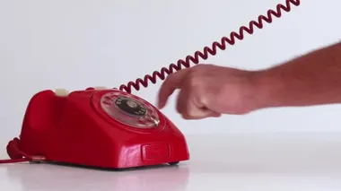 Beyaz arkaplan üzerinde sol taraftaki eski kırmızı telefondan aranıyor
