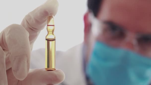 Biomedisch Onderzoeker Kijkt Verticaal Naar Injectieflacon Met Bruin Vaccin — Stockvideo