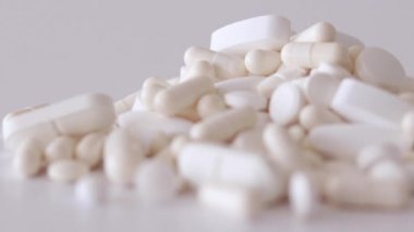 Seçici odak noktasında bir sürü beyaz hap, tablet ve kapsül