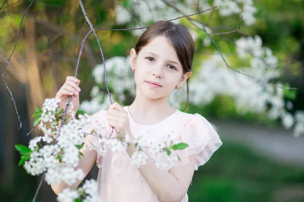 Portrait of little girl in blooming apple tree garden — Stock Photo, Image