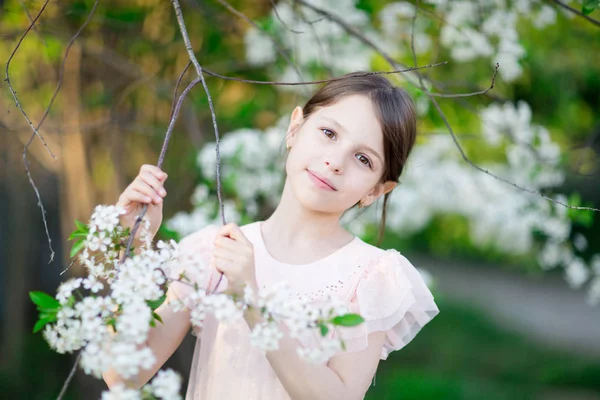 Entzückendes kleines Mädchen im blühenden Apfelbaumgarten — Stockfoto