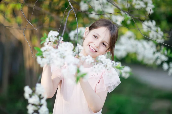 Bedårande liten flicka i blommande apple tree garden — Stockfoto