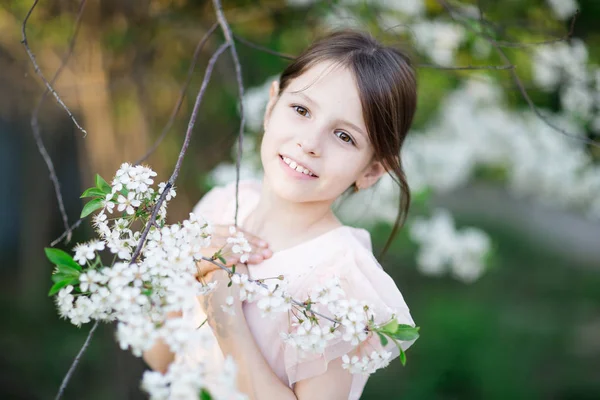 Bedårande liten flicka i blommande apple tree garden — Stockfoto