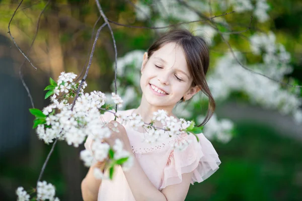 Dreaming little girl in blooming apple tree garden — Stock Photo, Image