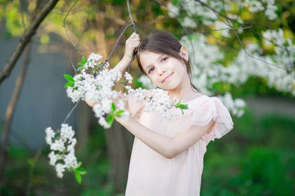 Adorable niña en el jardín de manzanos en flor —  Fotos de Stock