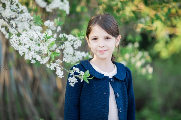 Bedårande liten flicka i blommande apple tree garden Royaltyfria Stockfoton