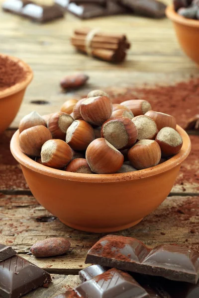 Hazelnuts in bowl and chocolate — Stock Photo, Image
