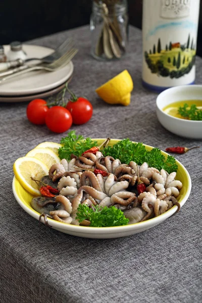 Сырой осьминог в керамической миске на кухонном столе — стоковое фото