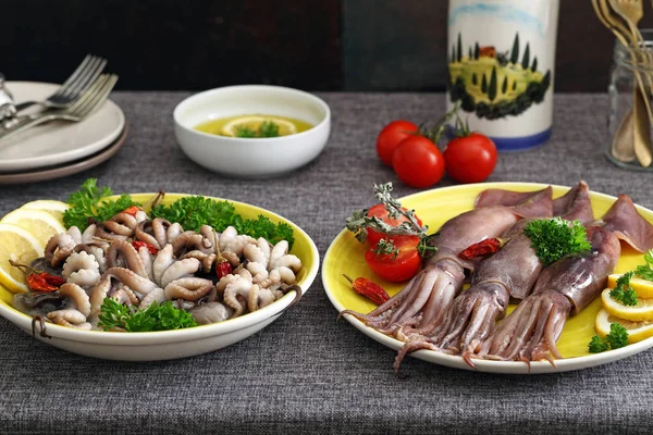 Raw baby octopus and fresh squid on kitchen table background — Stock Photo, Image