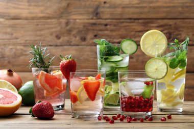 Limonata limon, salatalık, limon, greyfurt, çilek, nane yaprakları ve garnet tohum ile ahşap masaya servis.
