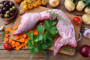 Baharatlı çiğ tavşan dilimleri sarımsak çatalı ve kırsal meşe masasında kasap..