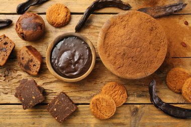 Keçiboynuzu bakla ve keçiboynuzu tozu kopya alanı - vegan vejetaryen yemek ve içecekler için sağlıklı organik madde ile ahşap arka plan üzerinde