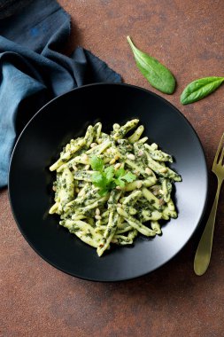 Sebzeli taze makarna masada siyah tabakta.