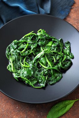 Siyah tabakta peçeteyle doldurulmuş ıspanak, üst manzara.