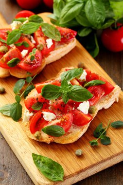 Domatesli iki ekmek tostu, sarımsak ve fesleğenli kapari.