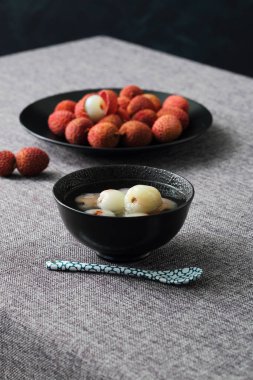 tasty litchi fruits on dark background clipart