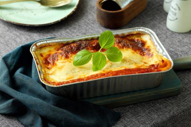 Gri masa arkasında İtalyan lazanyası bolonez.