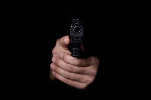 Le mani dell'uomo mirano con la pistola . Immagine Stock