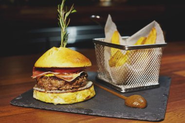 Burger Dana eti, mavi peynir, pastırma, domates, kaşar peyniri ile.  