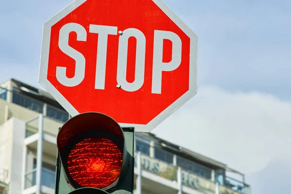 Red traffic light and a stop sign. — Stock Photo, Image