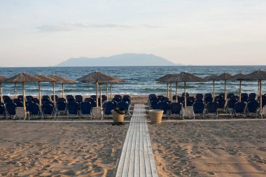 Plajda plaj sandalyeleri ve şemsiyeler.