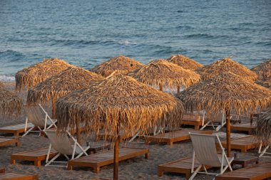 Plajda plaj sandalyeleri ve şemsiyeler.