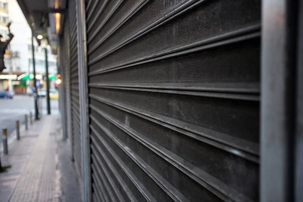 Μεταλλική πύλη προστατεύοντας ένα κατάστημα. Κλείσιμο καταστήματος. — Φωτογραφία Αρχείου