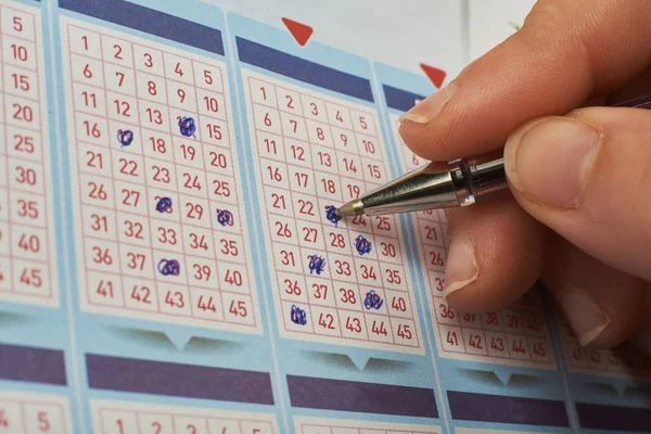 Primo piano del numero di marcatura a mano sul biglietto della lotteria con penna . Foto Stock