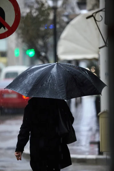 Kvinna i regn promenader med paraply. — Stockfoto