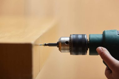 Çalışan bir elektrik scr ile ahşap bir tabloya bir vida vidalama