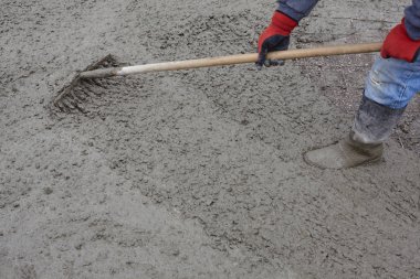 worker puts concrete on the ground