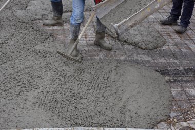 workers pouring wet concrete using concrete bucket. Industrial c