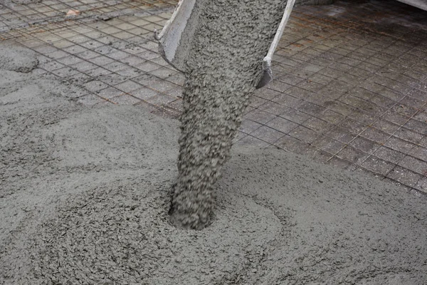 Mokrý beton padá z betonového kbelíku. Průmyslová stavba — Stock fotografie