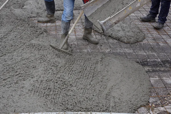 workers pouring wet concrete using concrete bucket. Industrial c