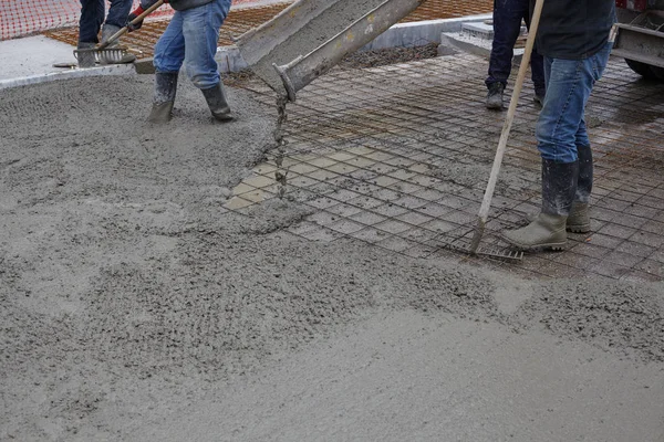 workers pouring wet concrete using concrete bucket. Industrial c