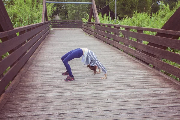 Flicka gör Chakrasana yoga position — Stockfoto