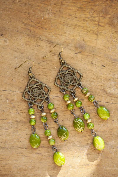 Belles boucles d'oreilles sur fond en bois — Photo