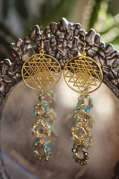 Beautiful earrings with sacred geometry — Stock Photo, Image