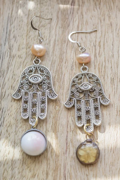 romantic earrings on wooden background