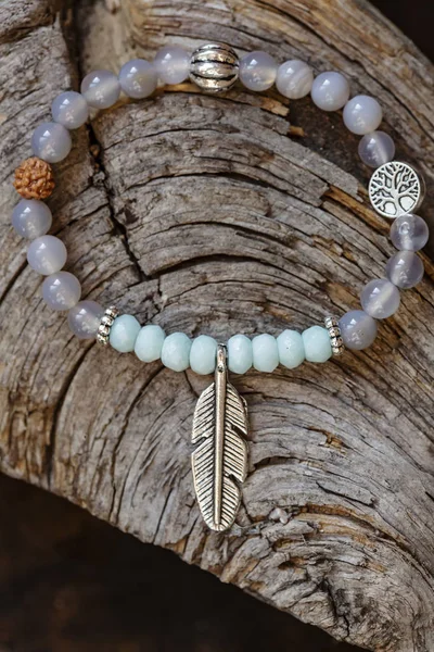 Mineral Stone Yoga Bracelet Metal Feather Pendant Wooden Background — Stock Photo, Image