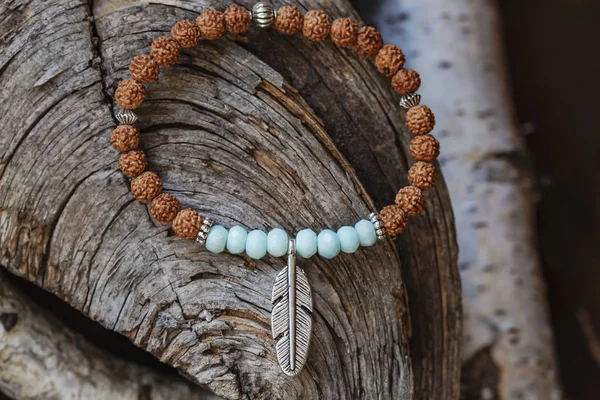 Mineral Stone Yoga Bracelet Metal Feather Pendant Wooden Background — Stock Photo, Image