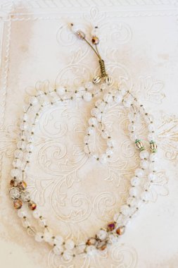 Beyaz ahşap dekoratif arka planda doğal mineral boncuklu mücevher kolyesi.