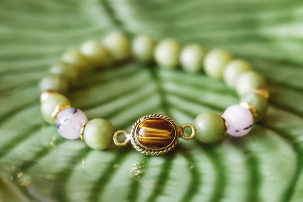 Tyger Eye Mineralstein Jade Mineralperlen Modisches Armband Auf Grünem Hintergrund — Stockfoto