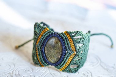 Beyaz dekoratif arka planda doğal mineral taşından bilezik.