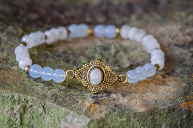 Beautiful mineral moon stone bracelet on rocky background