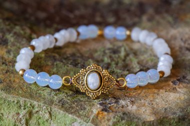 Beautiful mineral moon stone bracelet on rocky background