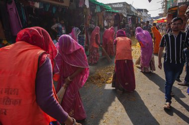 Puşkar, Hindistan, Rajasthan, 13 Şubat 2018: Hintli kadınlar Pushkar caddesini şenlikli çiçeklerden temizliyor