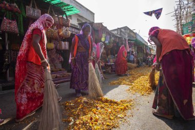 Puşkar, Hindistan, Rajasthan, 13 Şubat 2018: Hintli kadınlar Pushkar caddesini şenlikli çiçeklerden temizliyor