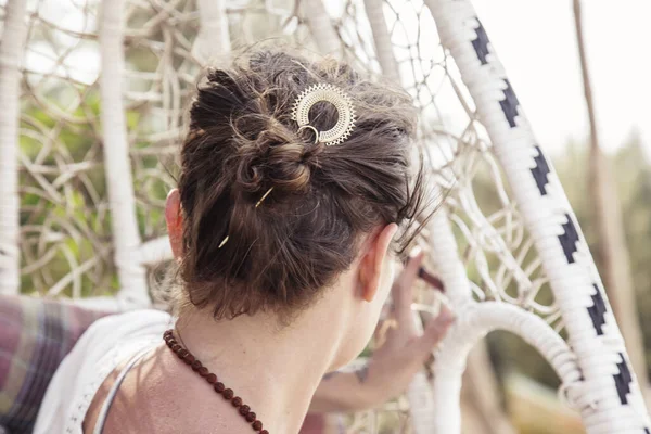 Elegant woman wearing metal hair pin in her hair bun