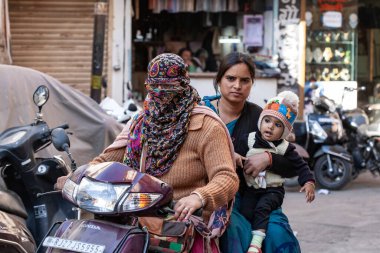 Udaipur şehri, 8 Şubat 2018: Udaipur şehir merkezinde motosiklet süren eşarplı kadın